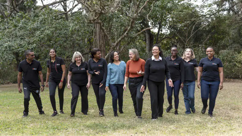 The Sense team walking together across a lawn, Durban