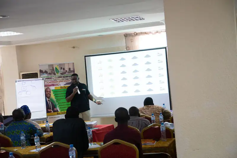 A trainer presents a slide to a room of seated participants