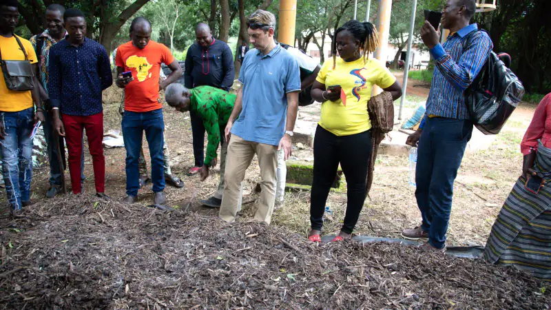 Farmers and a Sense consultant inspect a compost heap during a training, Burkina Faso