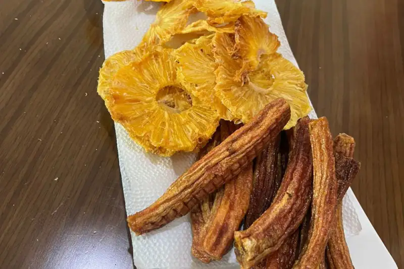 Dried pineapple rings and dried banana pieces on a plate, Benin