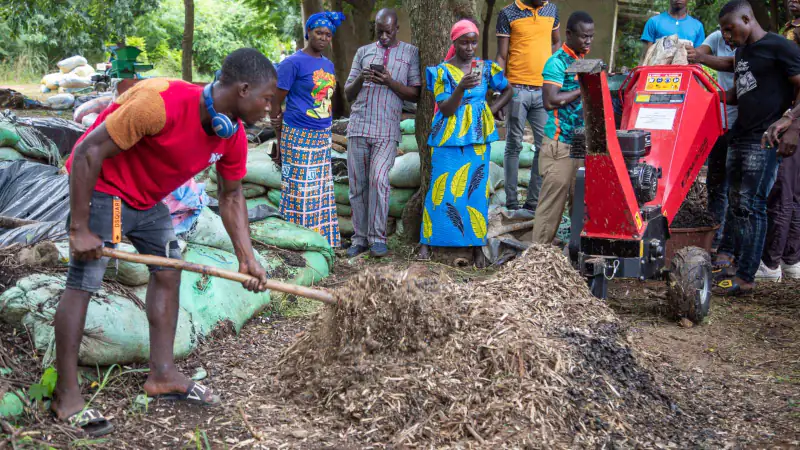 Young people make compost with a wood chipper at a practical training
