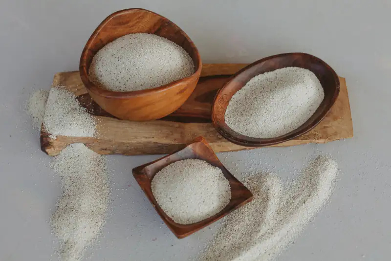 Milled fonio in three wooden bowls