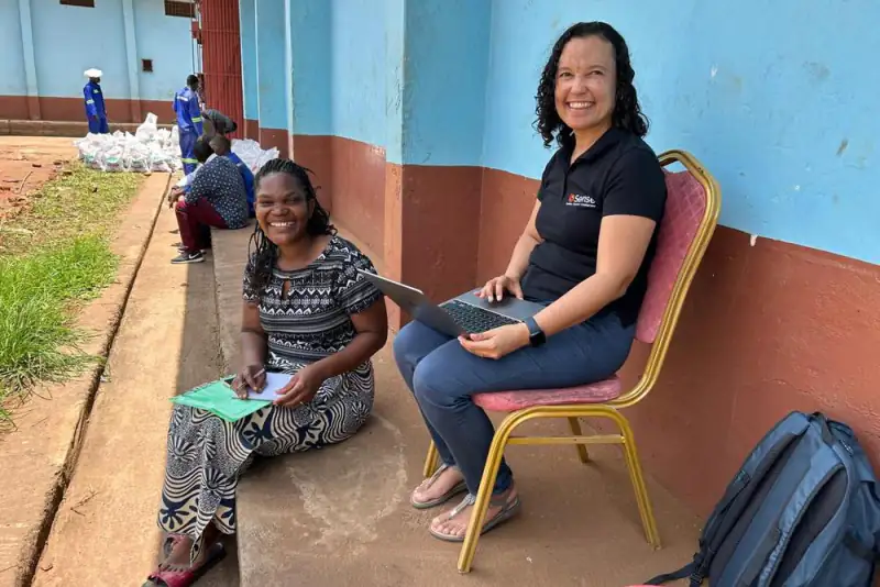 A Sense coach and a business owner working through notes and a laptop outdoors