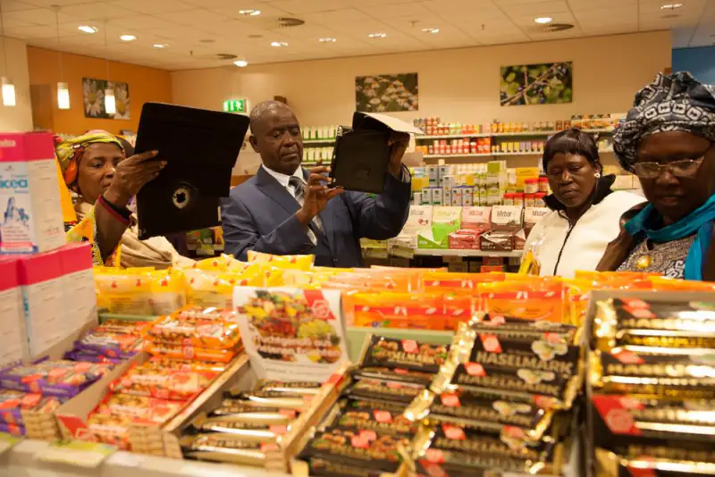 A study group examines products on supermarket shelves during a market visit
