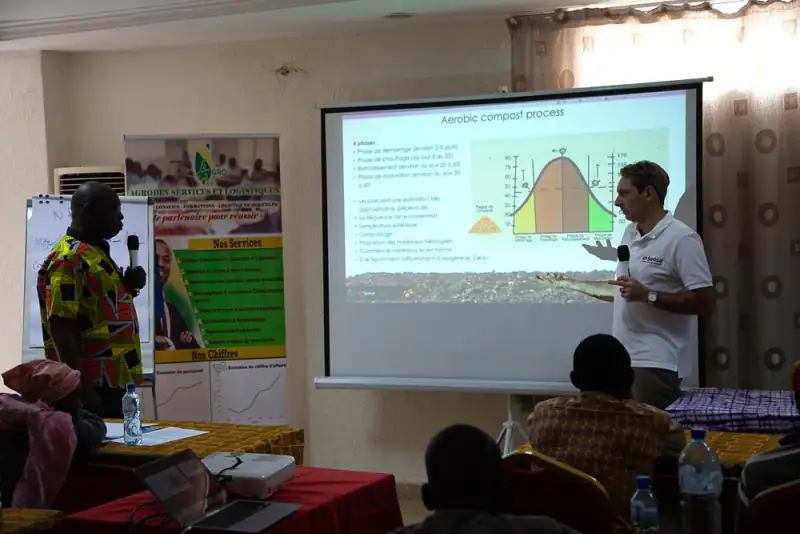 A Sense trainer explains the aerobic compost process on a slide at a workshop